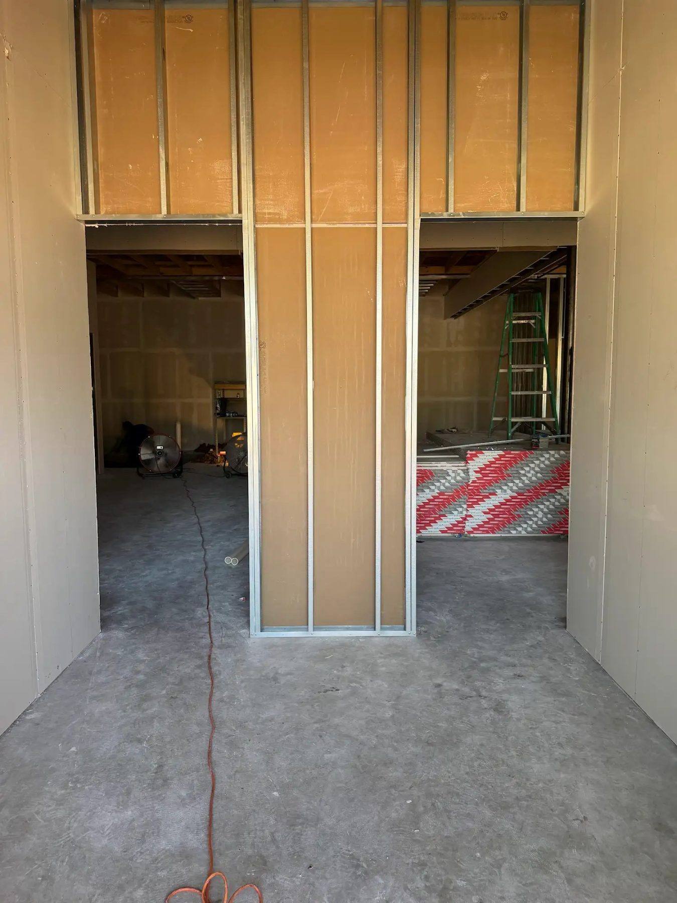 Framed and drywalled entry corridor of the Aleaf Insurance office under construction in Frisco, TX