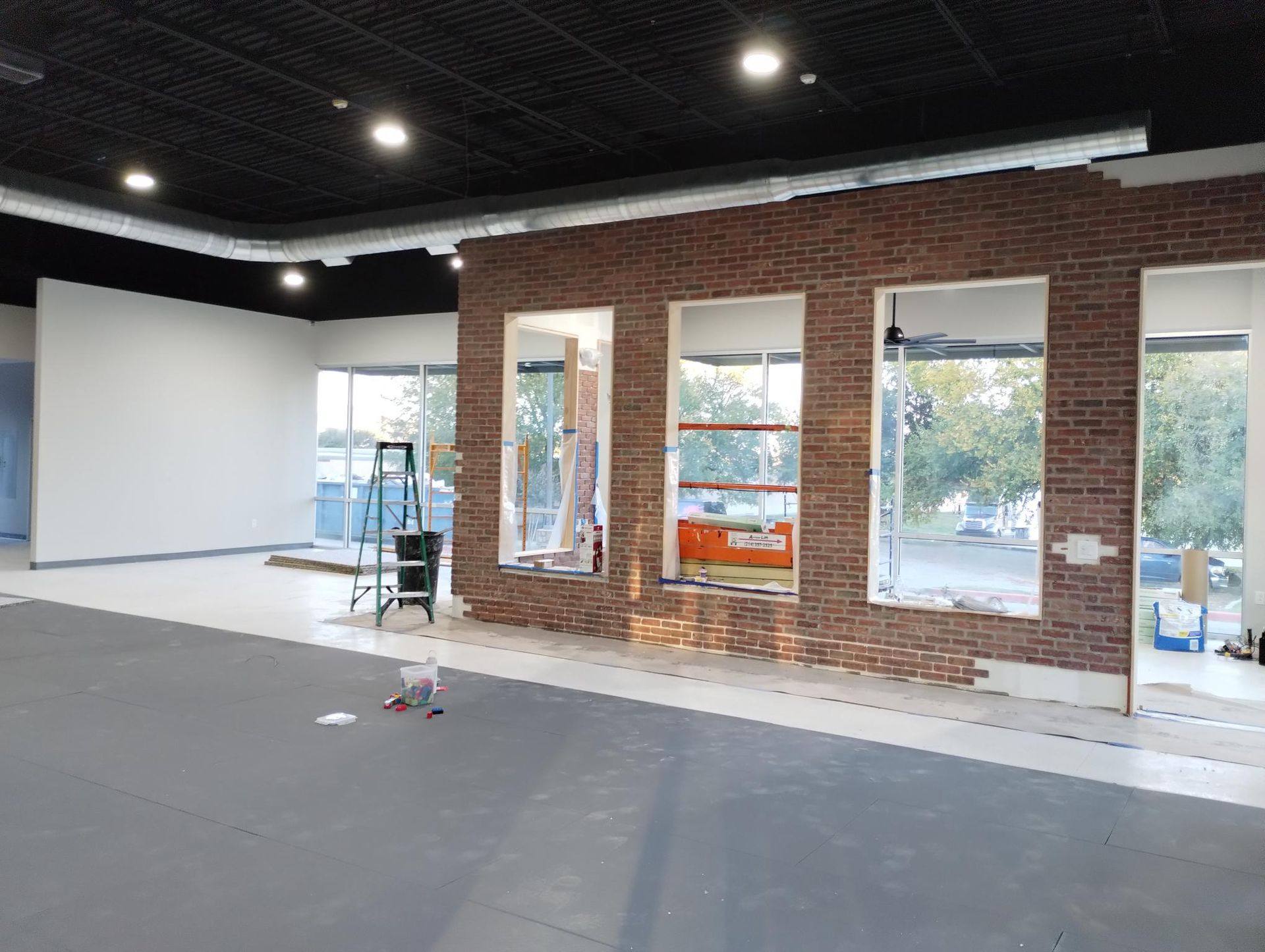 The brick feature wall with its three viewing windows, built between the spectator area and the training floor at Kung Fu Academy of North Texas in McKinney, TX