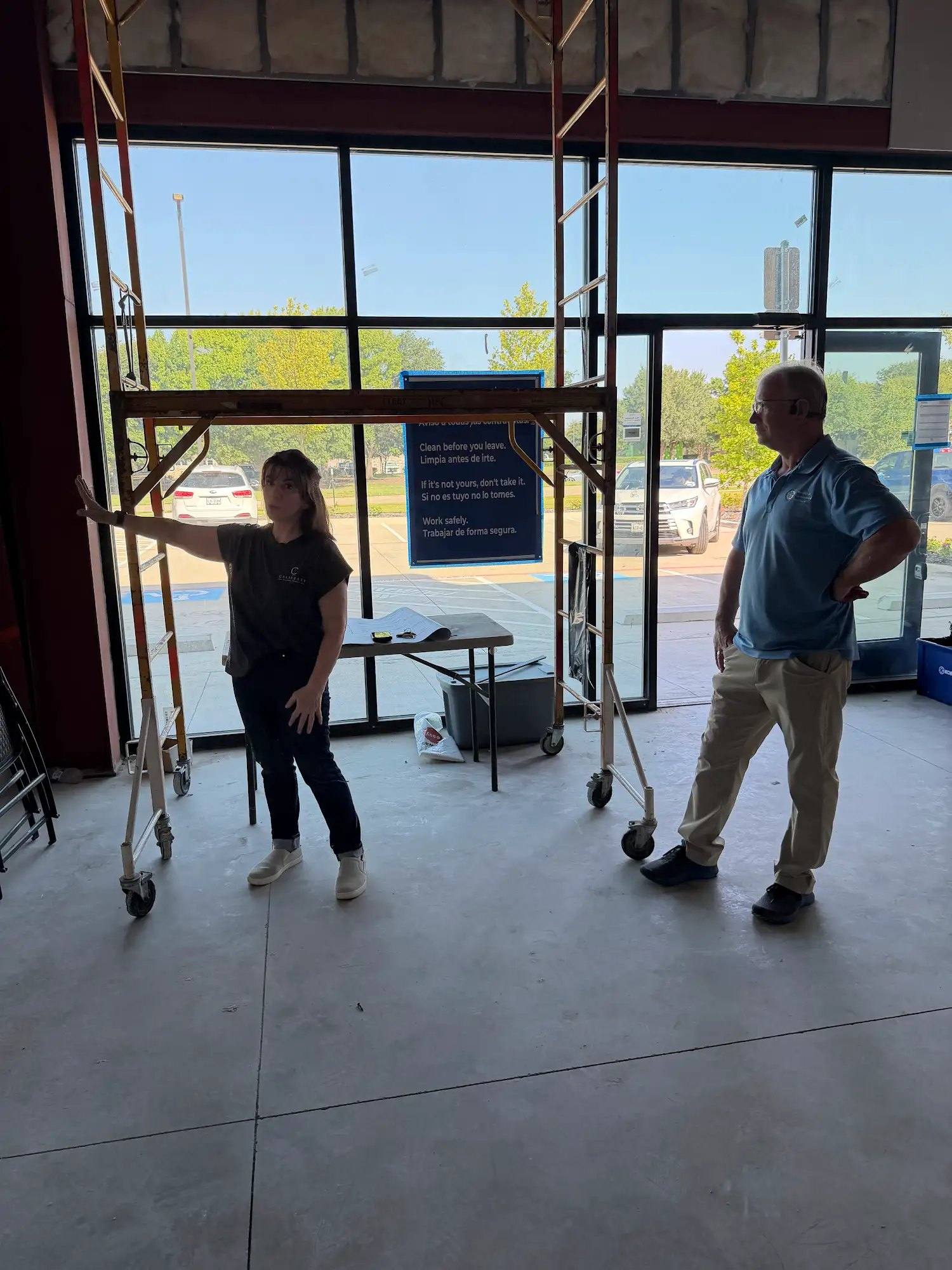 Storefront entry of the Calibrate Pilates Studio suite in McKinney, TX before the finish-out, with scaffolding inside the glass