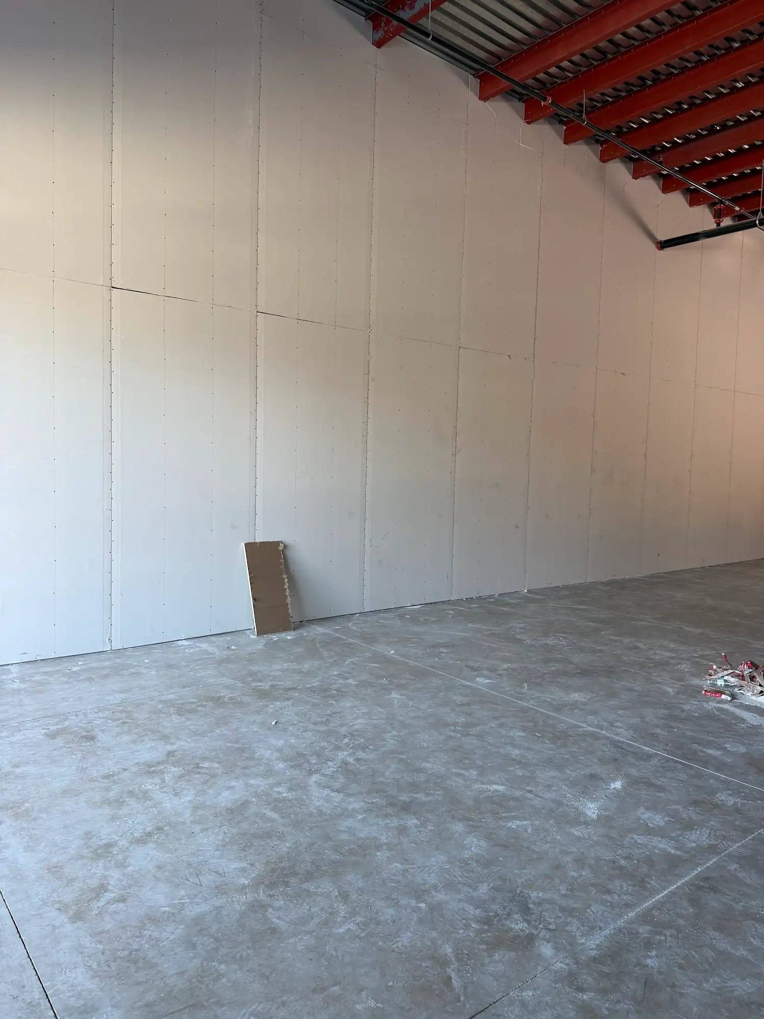 Finished drywall on the demising wall of the Calibrate Pilates Studio suite in McKinney, TX