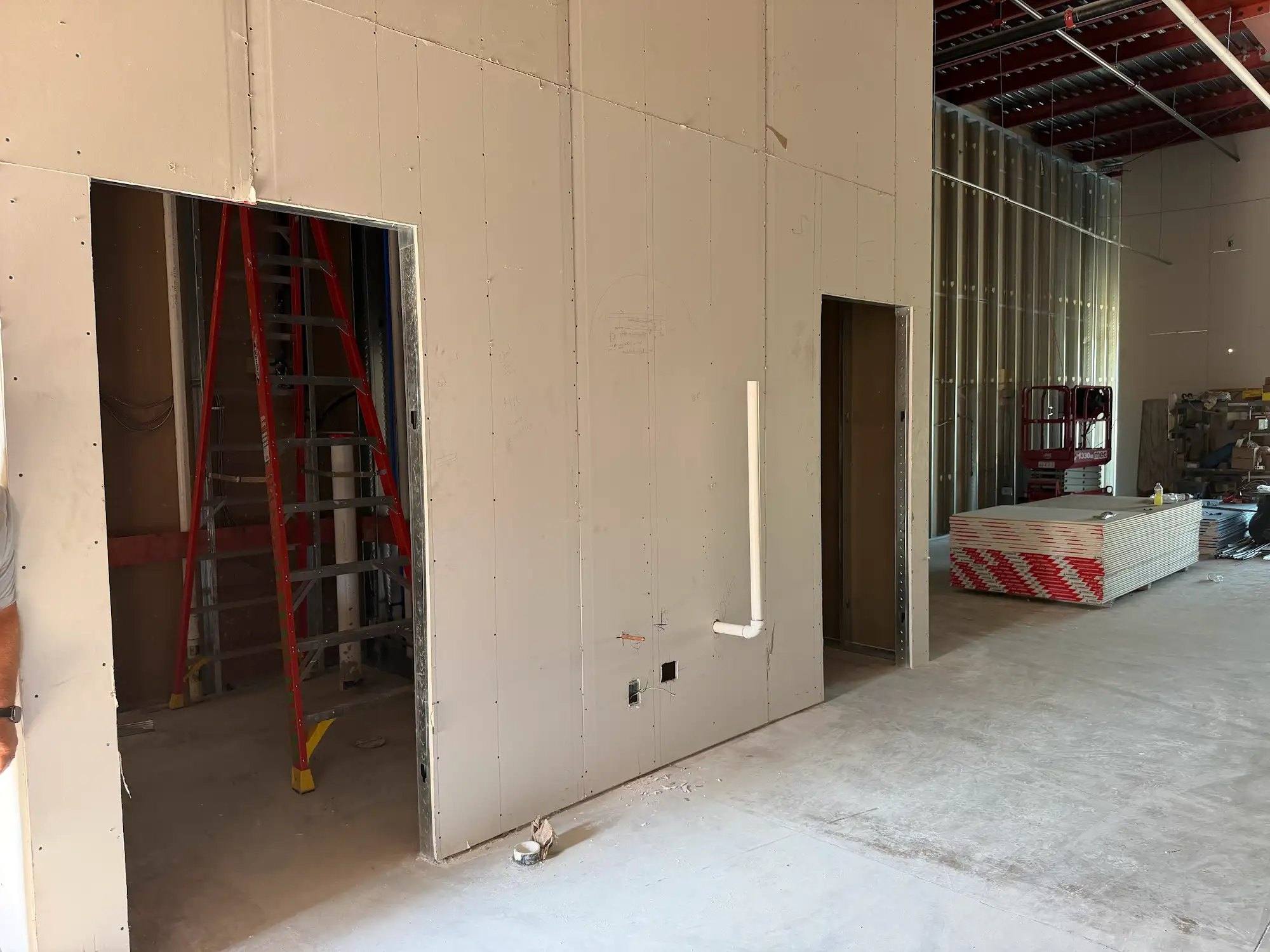 Restroom walls drywalled with door openings framed at Calibrate Pilates Studio in McKinney, TX