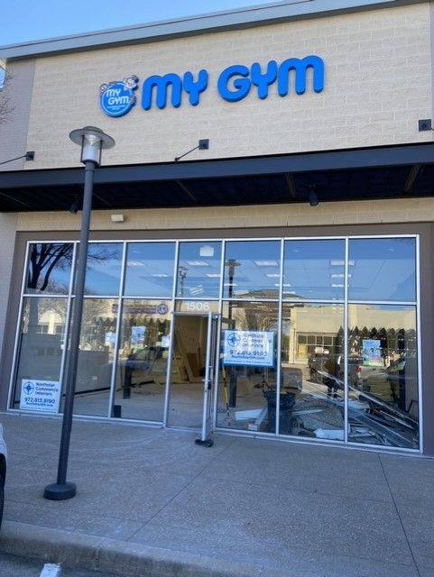 The My Gym storefront at The Village at Allen with the new signage up and NorthStar Commercial Interiors’ site signs still in the window