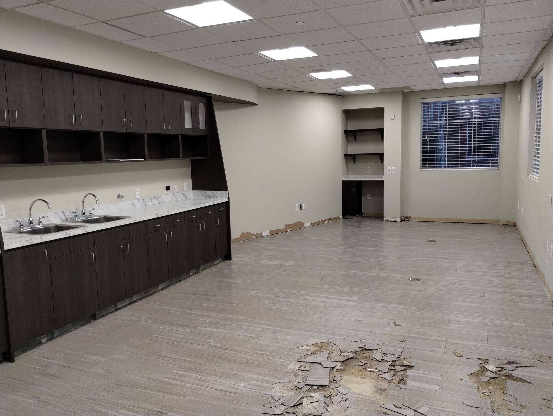 Before: the treatment room at Building Bridges Through Communication in Frisco, TX, with the old cabinetry in place and the floor breaking up