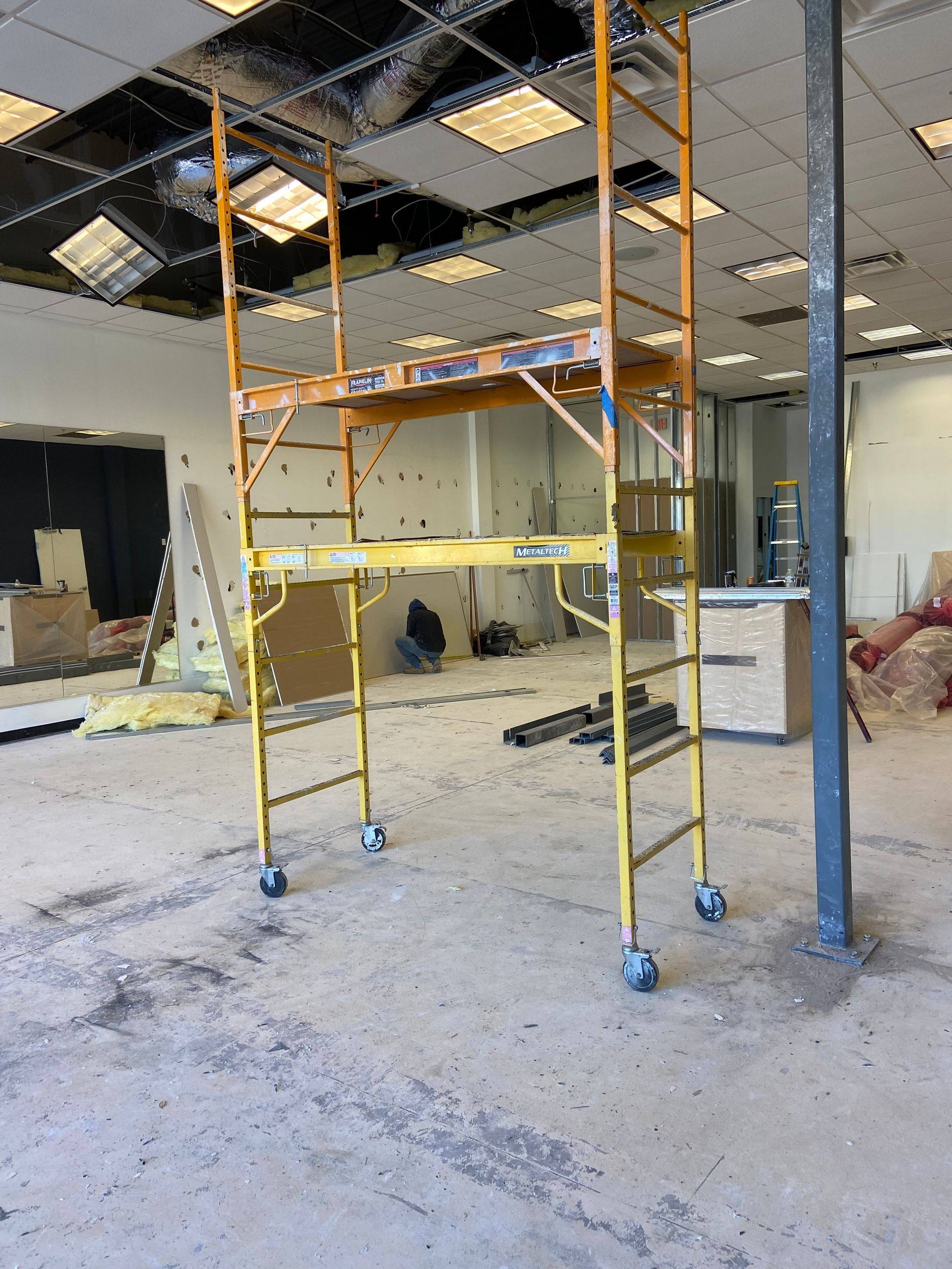 Progress: scaffolding up and the ceiling grid stripped out during the My Gym remodel in Allen, TX