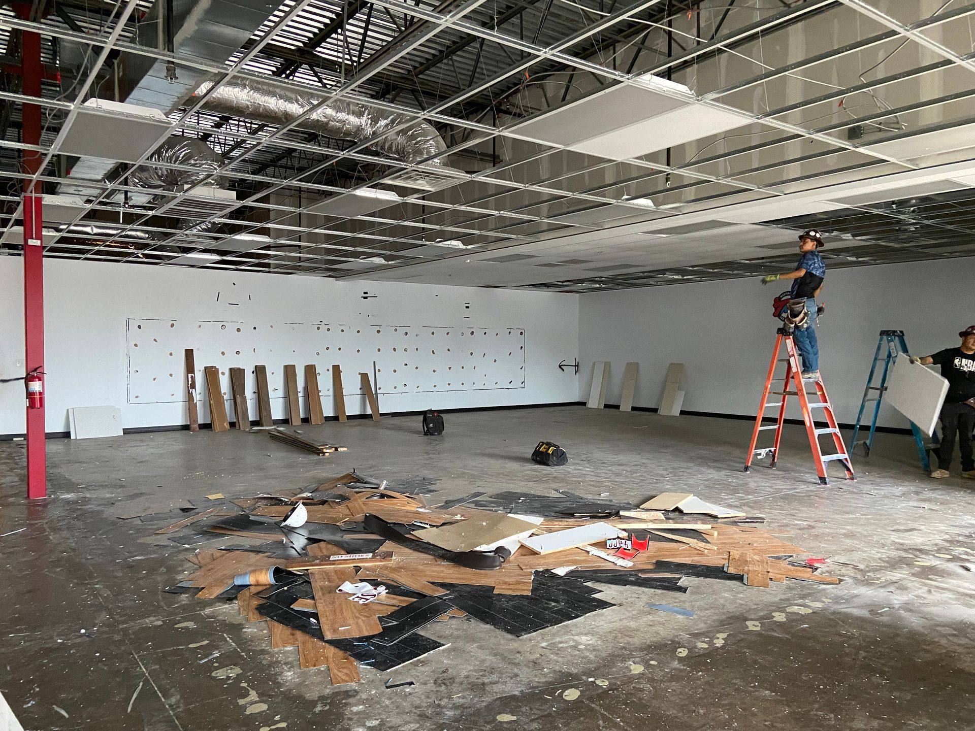 Demolition: flooring torn out and the ceiling grid stripped in the former martial arts studio that became The Back Nine Golf in Denton, TX