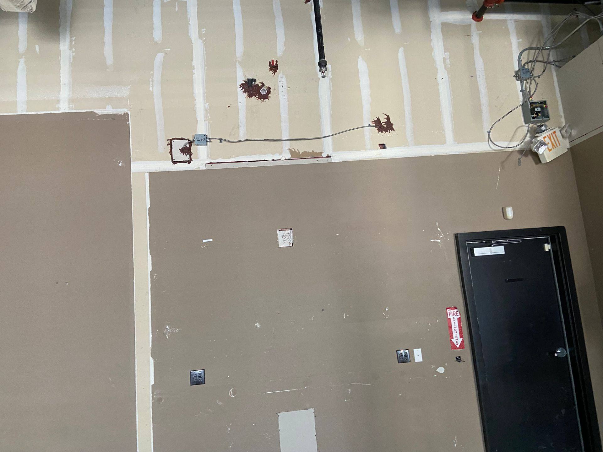 Before: exposed wiring on the back wall of the former dental office that became Rockstar Martial Arts in Frisco, TX